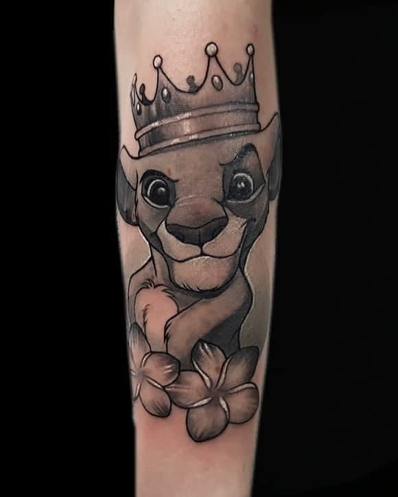 Tattoo van Simba van The Lion King, geplaatst in black and grey realisme op een onderarm bij Inksane tattoo en piercing